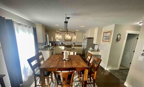A dining area with a wooden table, chairs, and a chandelier. - Centrally located, clean and comfy (Heber City)
