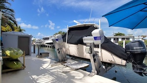 A marina with boats docked, a covered area with kayaks, and a small building. - Fisherman's dream!!, Privacy, Heated Pool,Hot Tub, 50' Dockage, Tiki, pets ok,   (Marathon)