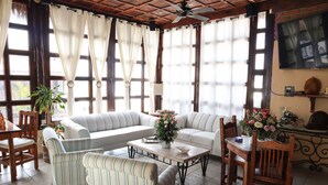 A cozy living room with a sofa, striped chairs, a coffee table, and a dining table. - Suite Giuseppe, luxury and comfort close to the malecon. Breakfast included  (La Paz)