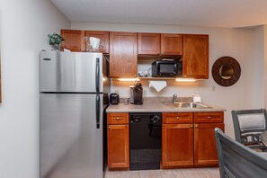 Kitchen area with modern appliances, a sink, and a refrigerator.
