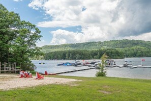 Relax by the serene lake with a dock and sandy beach area, perfect for a peaceful retreat.