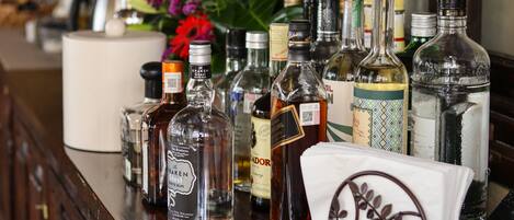 A bar area with various liquor bottles and a decorative napkin holder.