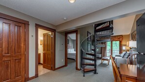 Un salón amplio con una escalera, una mesa de comedor y un sofá.