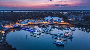 A marina with boats docked at piers, surrounded by buildings with waterfront views.