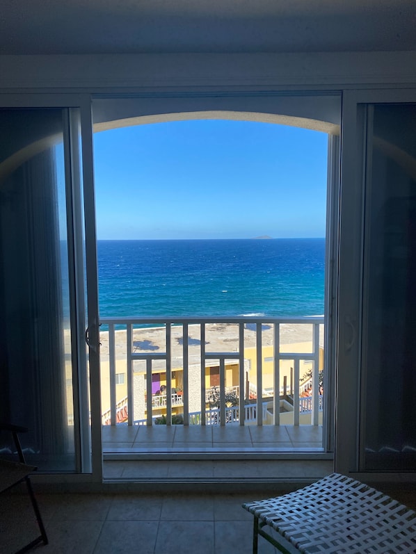 Un balcon avec vue sur l’océan et une plage.