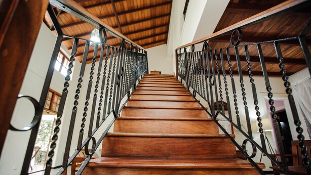 Un escalier en bois avec des rampes en métal menant à l’étage supérieur.