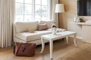 A cozy living room with a sofa, a coffee table, and a lamp.
