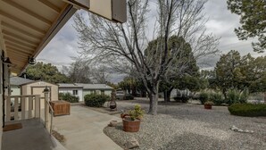 A residential driveway with a gravel path, a wooden gate, and a large tree. - **Newly Remodeled Home** 1 mile from Prescott Courthouse! (Prescott)