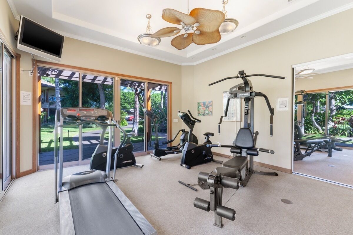 A gym with treadmills, elliptical machines, and weight equipment.