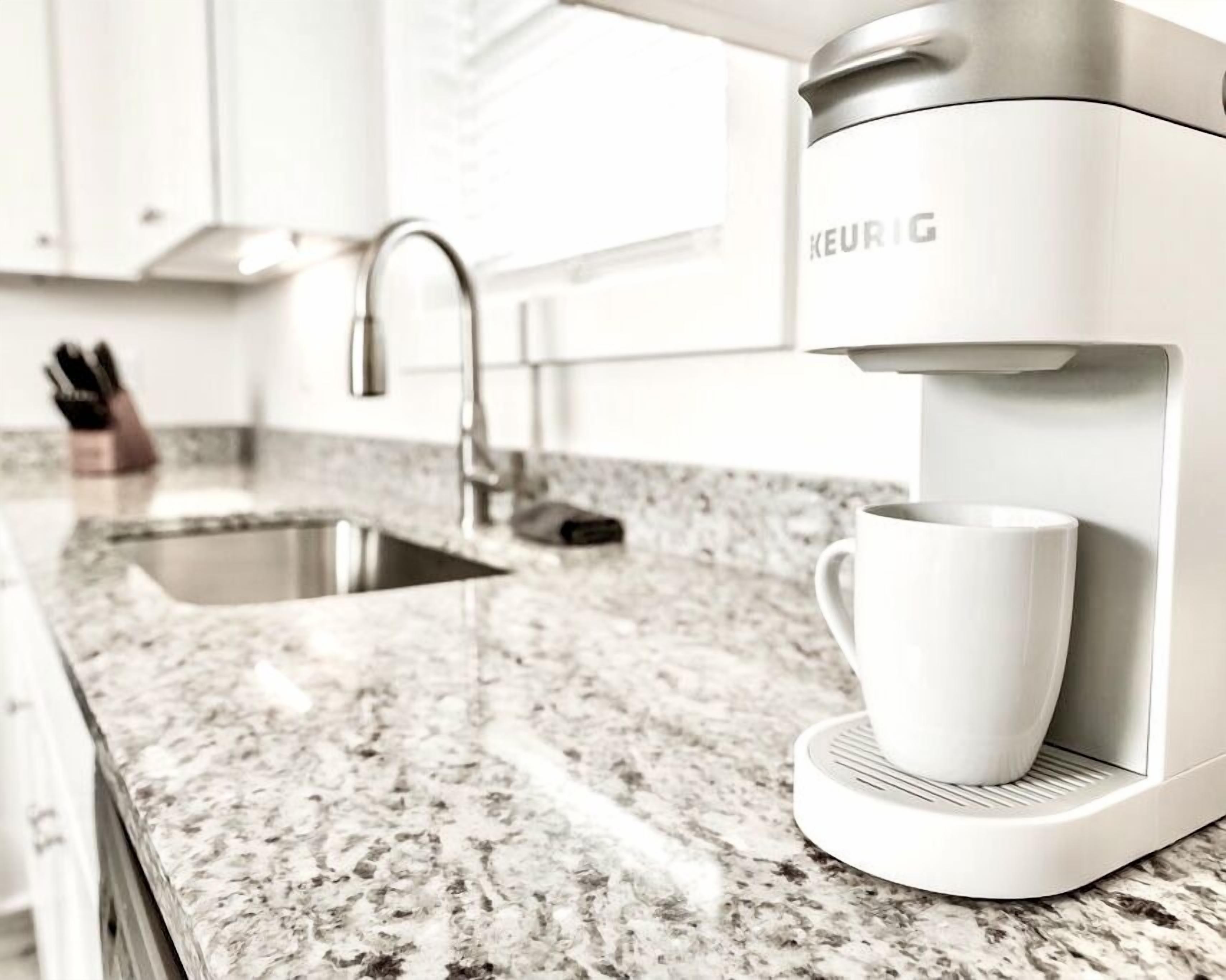 A modern kitchen with a built-in coffee maker, a sink, and a countertop.