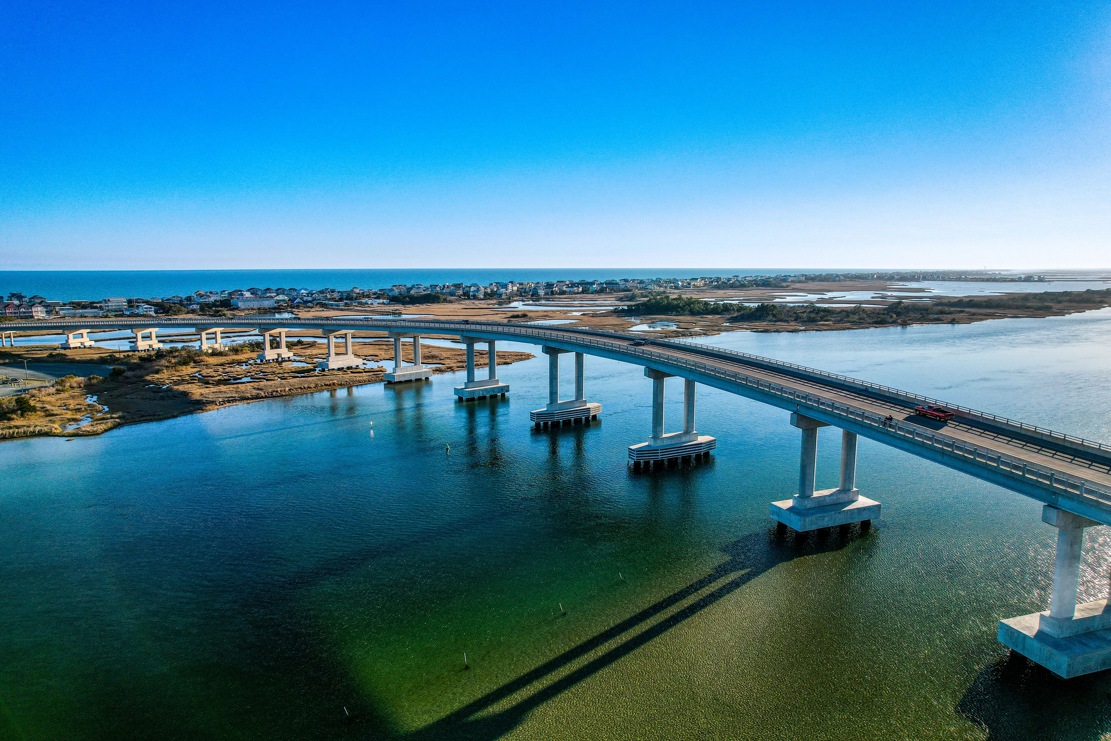 Vista aèria d'un pont sobre una massa d'aigua sota un cel serè.