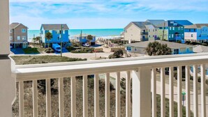 A coastal residential area with houses, a beach, and a clear sky.