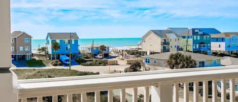 A coastal residential area with houses, a beach, and a clear sky.