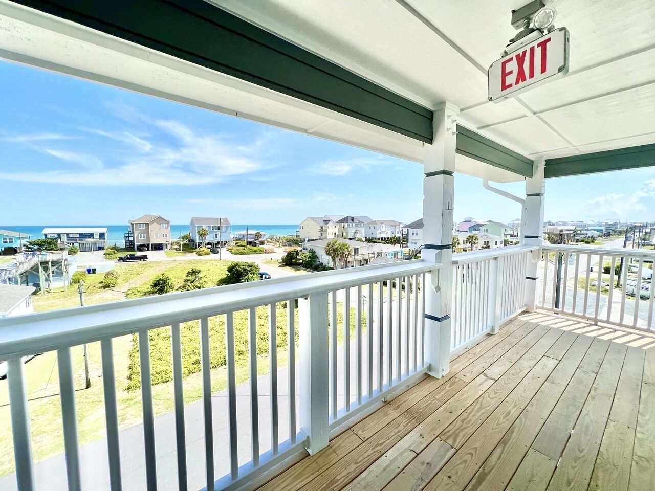 Un balcón con vista a una zona residencial y al océano.