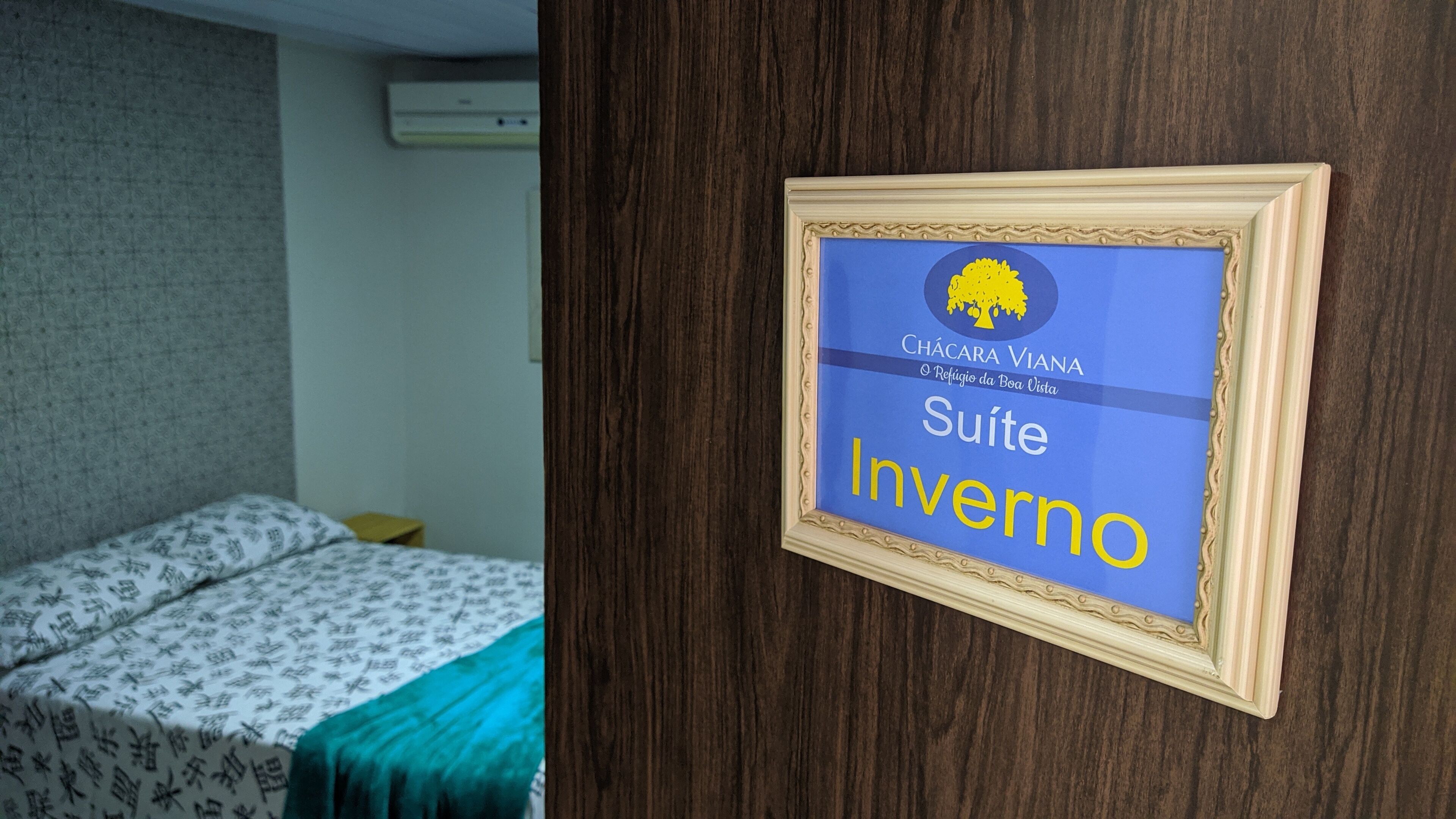 Un cartello incorniciato su una porta con la scritta 'Chácara Viana Suite Inverno'.