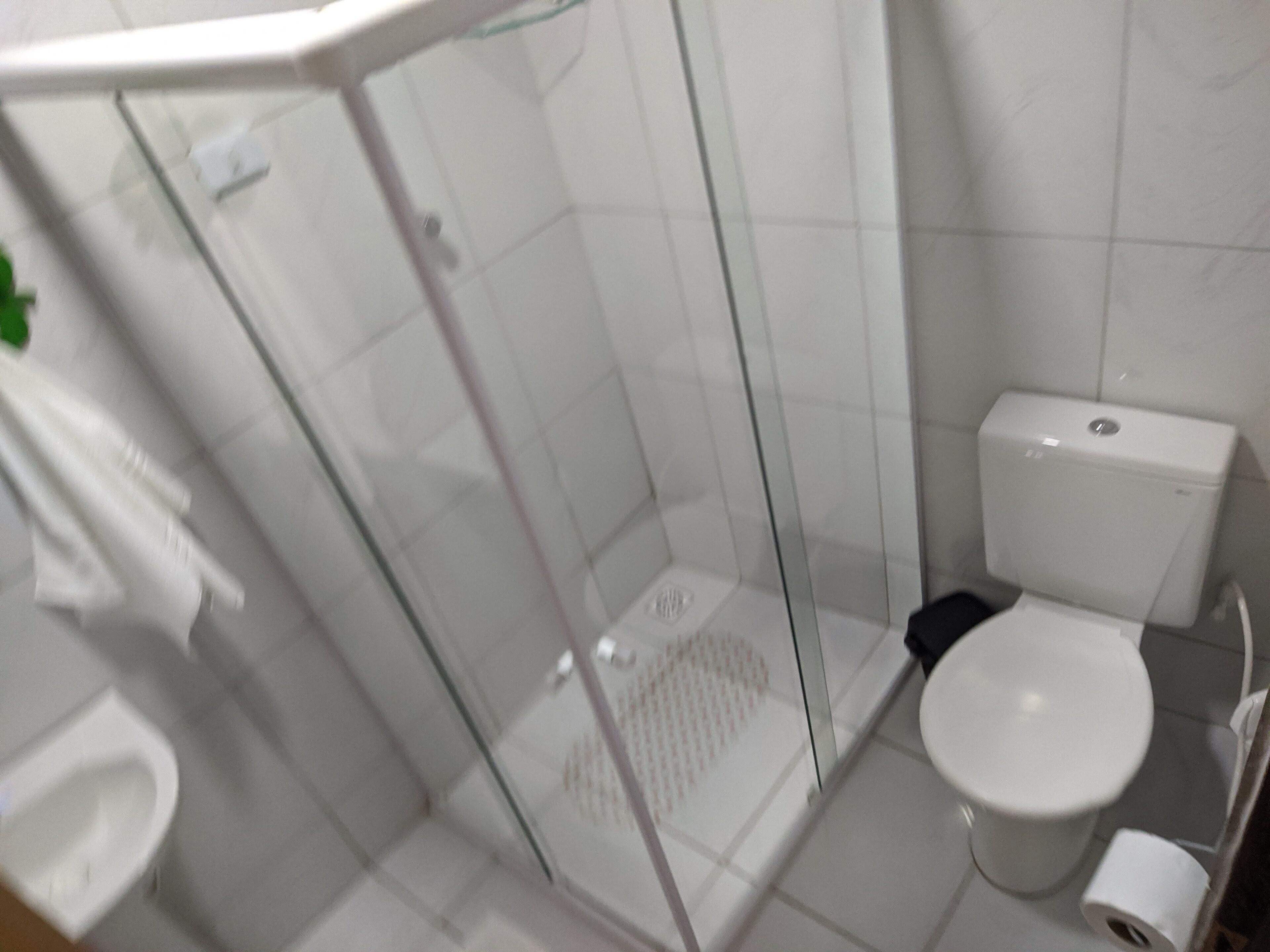 Een badkamer met een douchecabine, een toilet en een wastafel.