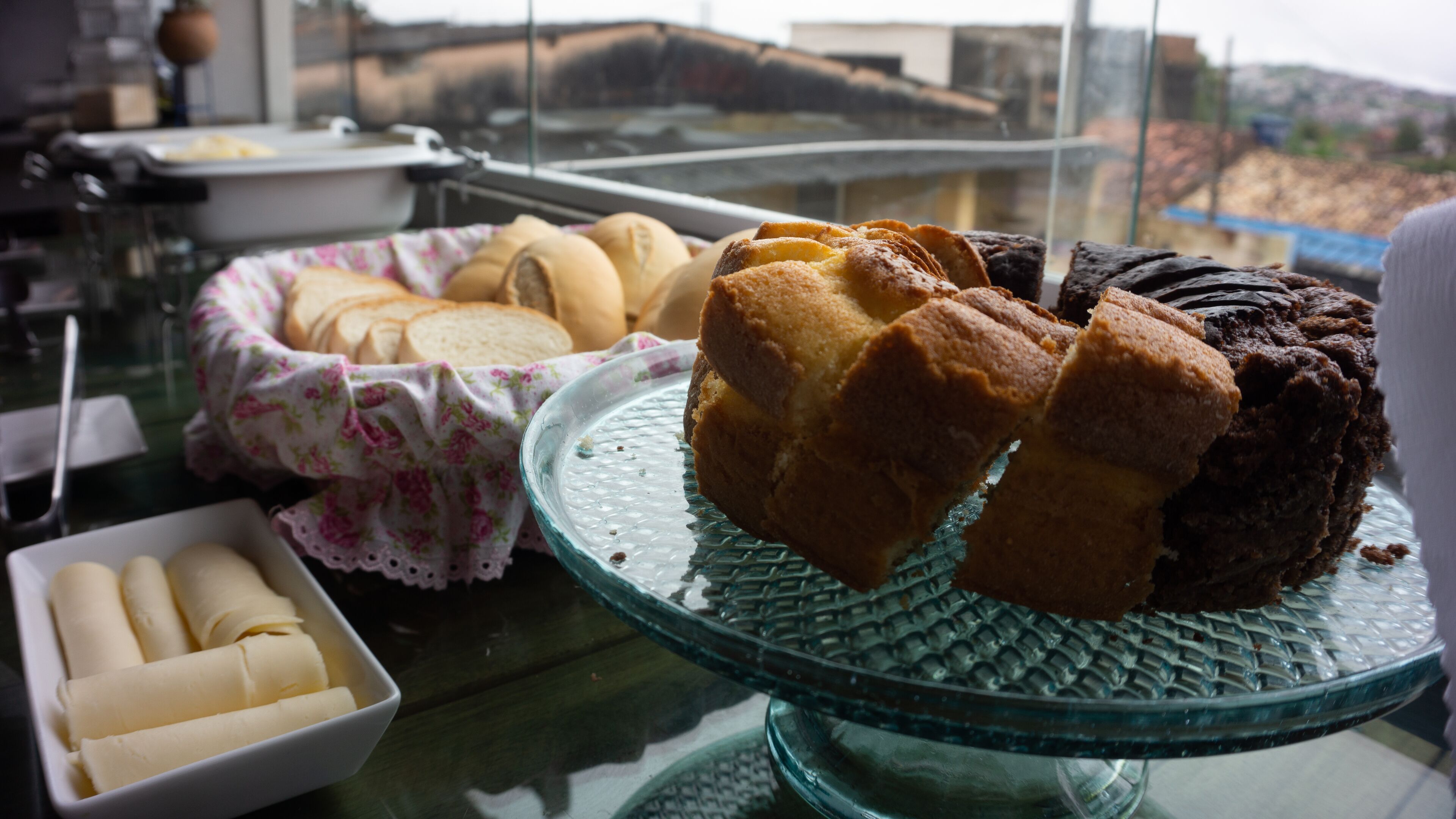 Una mesa de vidrio con diversas opciones de panadería, incluyendo pan y pasteles.