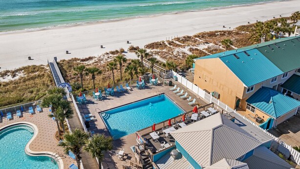 Um resort com piscina, acesso à praia e vista para o oceano.