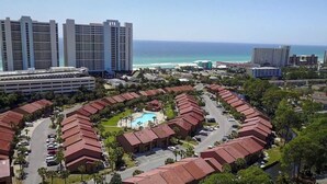 Um resort com piscina, vários edifícios e vista para o oceano.