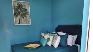 A bedroom with a single bed, a ceiling fan, and a painting of a tree on the wall. - Cozy 1 bed in Nassau best kept secret ! (Nassau)