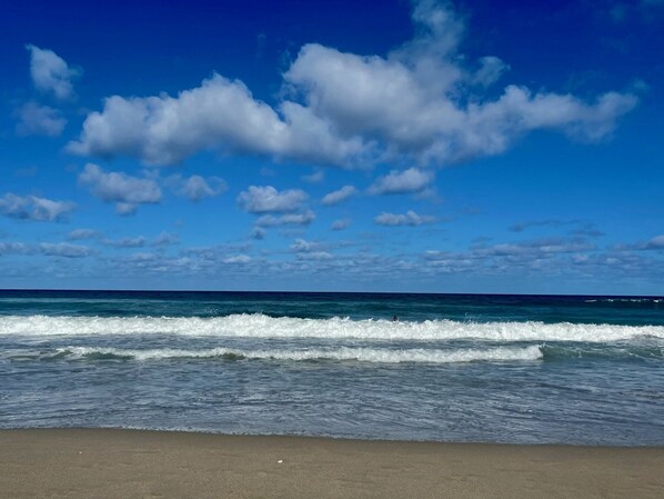 Uma praia com ondas e céu claro.