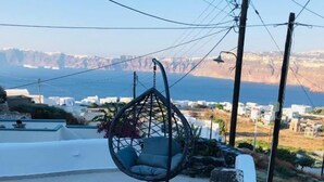 Un escalier en pierre mène à une plateforme blanche sur laquelle est suspendue une chaise.
