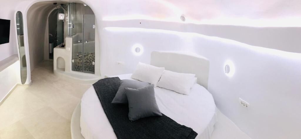 Un dormitorio moderno con cama, almohadas y un vestidor.