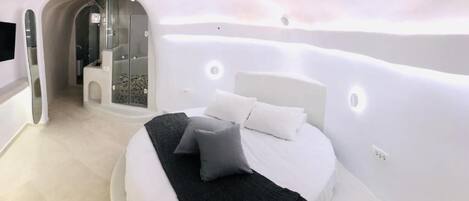 Un dormitorio moderno con cama, almohadas y un vestidor.