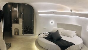 Une chambre à coucher moderne avec un lit aux lignes courbes, une petite salle de bain et un design architectural original.