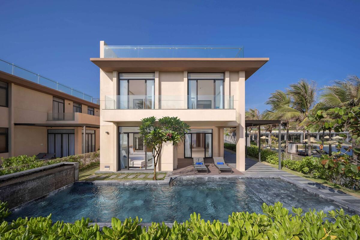 A modern two-story building with a swimming pool in front.