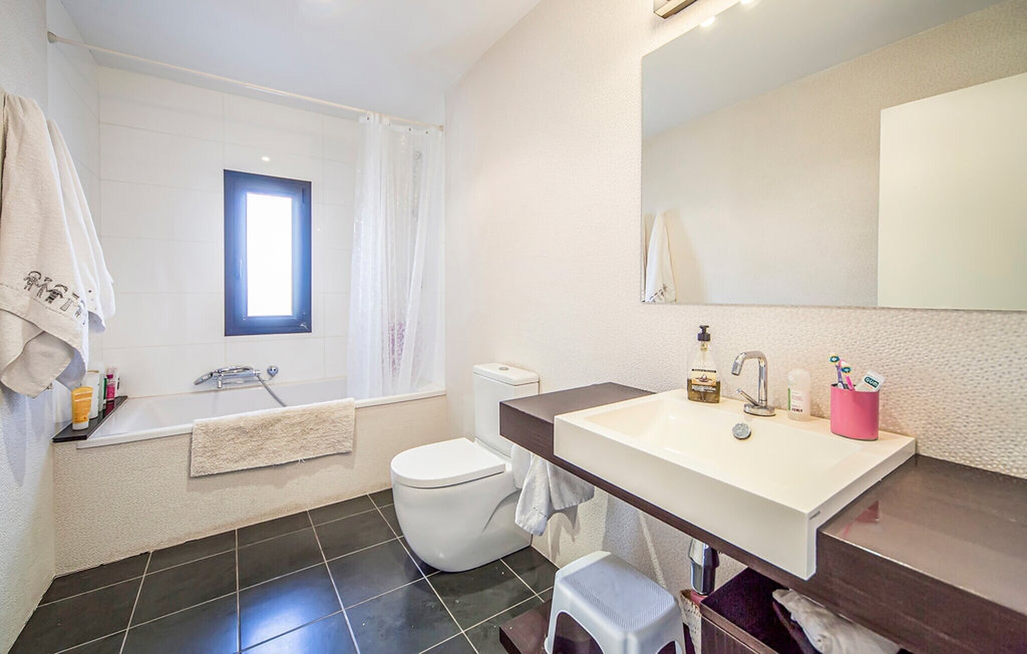 A modern bathroom with a bathtub, toilet, and sink.