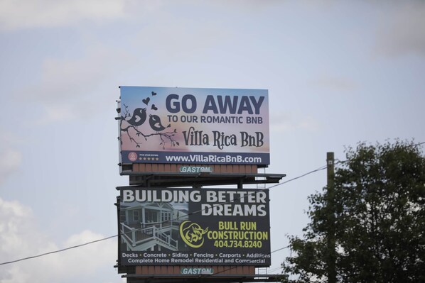 A billboard advertising Villa Rica BNB with a website link and a 5-star rating.