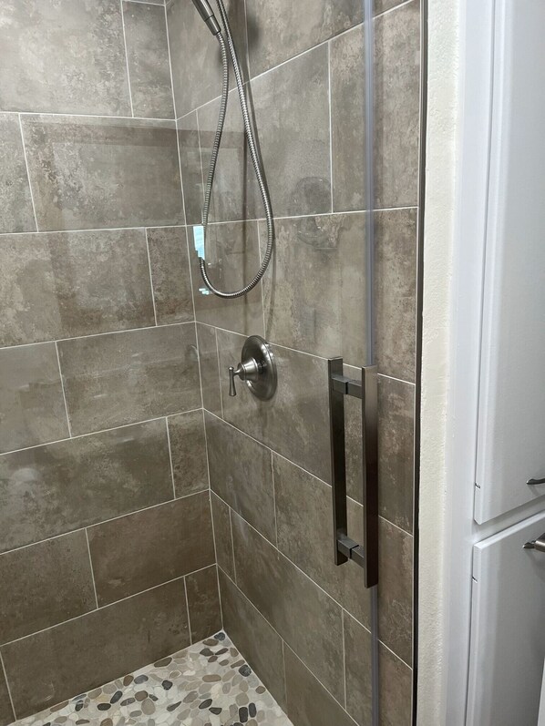 A shower area with tiled walls and a showerhead.