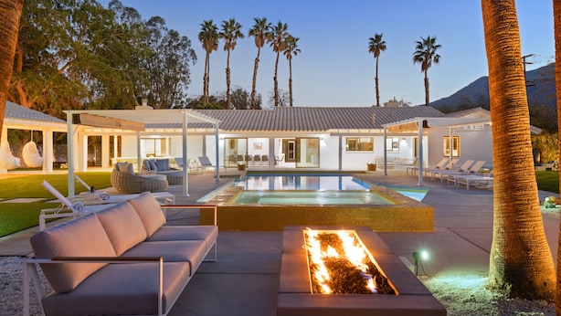 A modern outdoor pool area with lounge chairs, a fire pit, and a covered patio. - Solaris - Modern Mediterranean Estate with Pool, Spa and Fire Pit (Palm Springs)