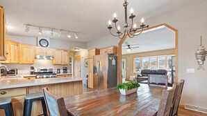 A spacious kitchen with wooden cabinets, stainless steel appliances, and a dining area with a wooden table and chairs. - Lake Front, NEW Sandy Beach, Big Buck Hunter & Pac-Man Arcade Games! Near Nisswa (Pequot Lakes)