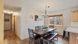 A dining area with a wooden table, chairs, a bench, a chandelier, and a window with a view. - Lake Front, NEW Sandy Beach, Big Buck Hunter & Pac-Man Arcade Games! Near Nisswa (Pequot Lakes)