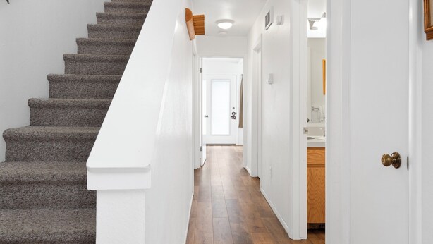 A staircase with carpeted steps leading to a white door. - Outpost: Pitchfork 2106 - Walk to Town Square! (Jackson)
