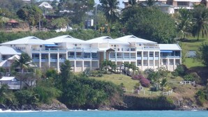 Ein Küstenhotel mit mehreren Gebäuden, einer Grünfläche und Blick auf das Meer.