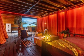 Una habitación acogedora con una cama, un escritorio, una silla, un televisor y vista a un lago.