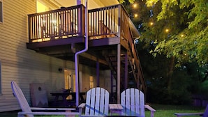 A house with a porch, outdoor seating, and a fire pit.
