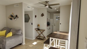 A living room with a grey sofa, a wooden coffee table, and a ceiling fan.