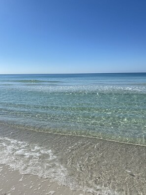 A beach with clear shallow waters and a sandy shore. - Fully Renovated, Steps from Beach with Gulf Views. Pet Friendly! (Panama City Beach)
