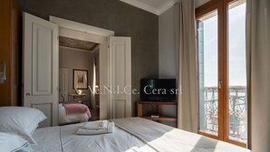 A hotel room with a bed, a television, and a balcony with a view. - Ve.N.I.Ce. Cera Tintoretto Suite (Venezia)