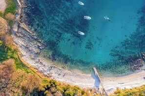 An aerial view of a coastal area with clear turquoise waters, rocky shorelines, and boats. - Holiday apartment Beach apartment Petra (Pula)