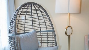 A room with a wicker chair, a floor lamp, and a carpeted floor. - Craftsman ranch (Lawrenceville)