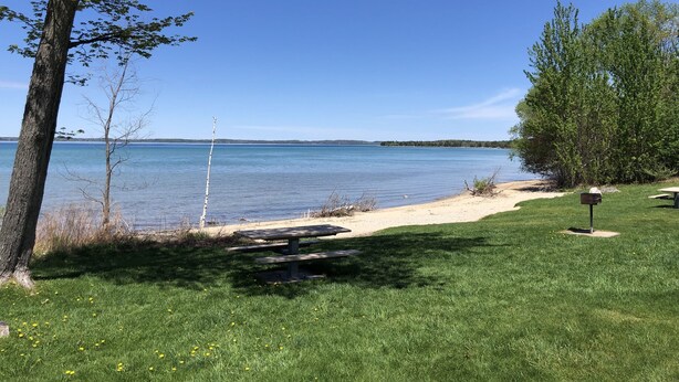 Un espace de pique-nique au bord du lac, équipé d’un banc et d’une boîte aux lettres.
