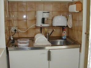 Une cuisine compacte équipée d’une machine à café, d’un grille-pain et d’un évier.