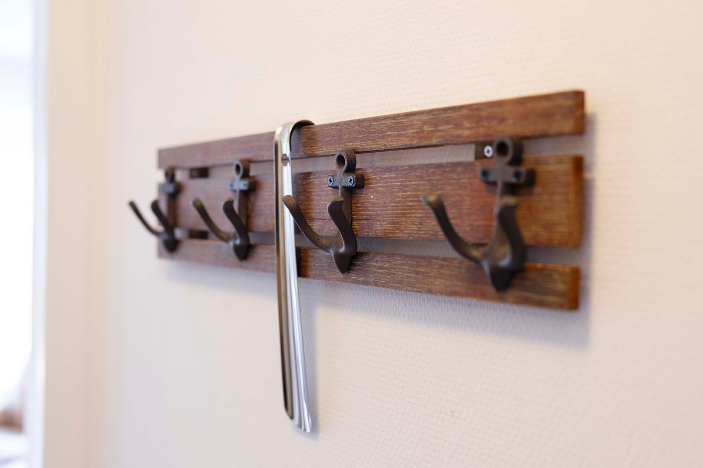 A wall-mounted coat rack with multiple hooks.