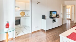 A modern apartment with a kitchen, a dining area, and a living room. - (OST35c) Holiday apartment "Sonnendeck" - Holiday apartment "Sonnendeck" for 2 persons (Timmendorfer Strand)