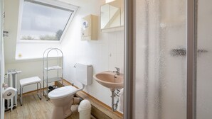 A compact bathroom with a toilet, sink, and shower. - (HER14b) Holiday apartment "Hartig 2" - Holiday apartment "Hartig 2" up to 2 persons (Timmendorfer Strand)